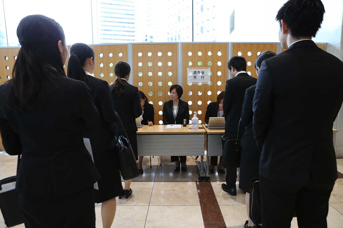 企業の採用面接の受付に並ぶ学生ら